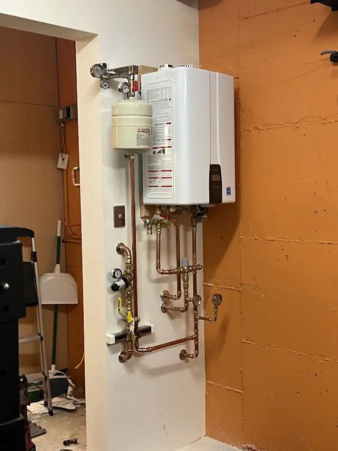 Plumbing technician inspecting water heater connections in Straban